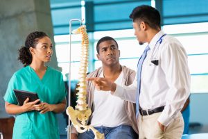 Doctor and nurse consulting with patient about back spine injury